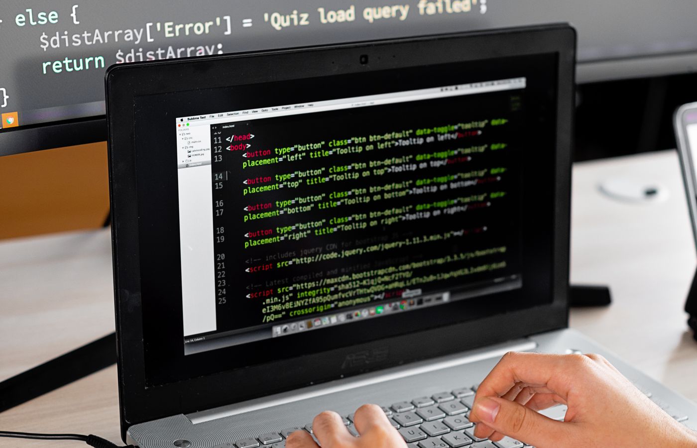 Developer researching software with a laptop and external monitor