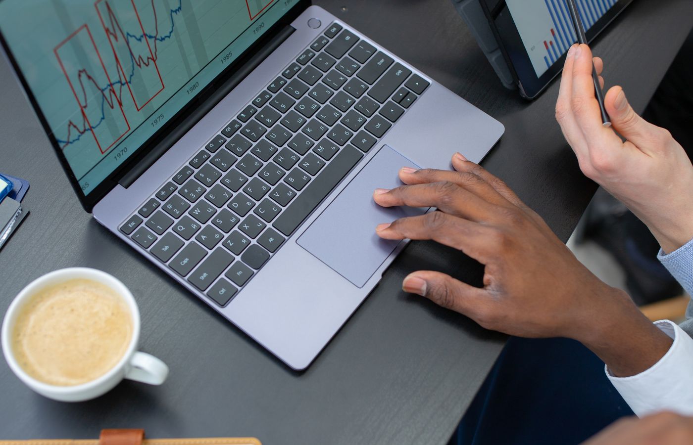 People reviewing charts together on a laptop and tablet