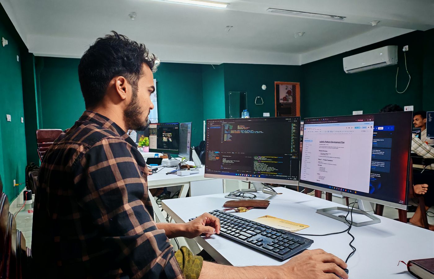 Developer working with source code on two monitors